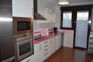 une cuisine avec des placards blancs et un comptoir rouge dans l'établissement El Cierzo de la Mata, à Mata de Quintanar