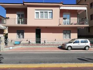 une voiture garée devant une maison rose dans l'établissement B&B Mila e Nan, à Borghetto Santo Spirito