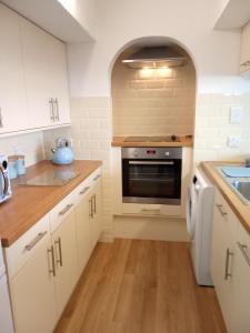 a kitchen with white cabinets and a stove at Ocean View in Cawsand