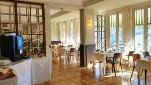 a dining room with tables and chairs and windows at Hotel Walter Au Lac in Lugano
