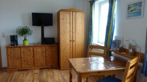 a living room with a wooden cabinet and a table at Ferienwohnung 2, Neuendorf - Hiddensee in Neuendorf