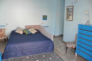 - une chambre avec un lit bleu et une commode bleue dans l'établissement B&B Mila e Nan, à Borghetto Santo Spirito