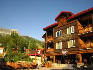 a large wooden building with tables in front of it at Cornerstone Lodge by Park Vacation Management in Fernie