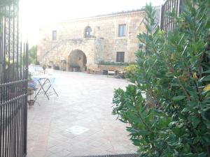 a stone building with a courtyard with a table and chairs at Le Querce di Cota in Troina