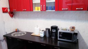 a kitchen counter with a sink and a microwave at Apartament Central Miguel in Turda