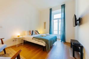 - une chambre avec un lit et une grande fenêtre dans l'établissement The Rossio Studio, à Lisbonne