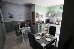 a dining room with a table and chairs and a kitchen at La casa di Luce in Reggio Calabria