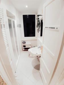 baño blanco con lavabo y ventana en B&B Lupin Trento, en Trento 23 fotos más
