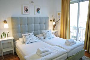 sypialnia z dużym łóżkiem i dużym oknem w obiekcie Hotel Delfin w mieście Zadar