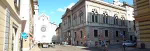 Un grupo de personas caminando por una calle al lado de un edificio. en B&B Lupin Trento, en Trento