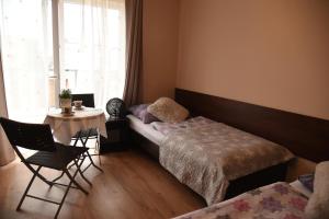 una camera da letto con un letto, un tavolo e delle sedie di Nestor II a Mrzeżyno Altre 3 foto