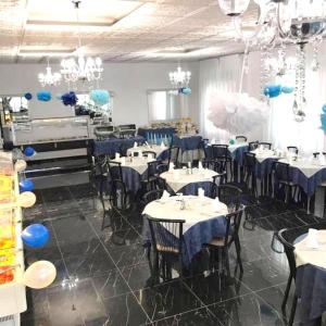 jadalnia z niebieskimi stołami, krzesłami i żyrandolami w obiekcie Hotel Atmosfere Beach w Cesenatico