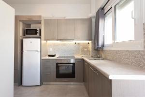 a kitchen with a white refrigerator and a sink at D. Apartments in Kalamata