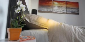 a table with a vase of flowers next to a bed at Penthouse SEAFLOWER in Blankenberge
