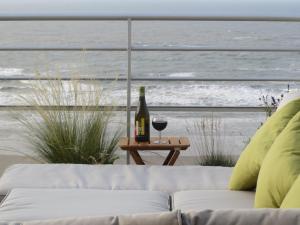 eine Flasche Wein und ein Glas auf dem Tisch in der Unterkunft Penthouse SEAFLOWER in Blankenberge