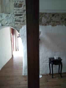 Habitación con mesa y pared de piedra. en Gite Rouge en Ménil-Vin