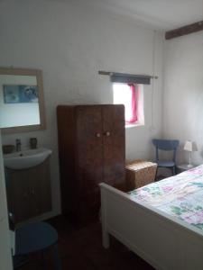 1 dormitorio con cama, lavabo y tocador en Gite Rouge en MÃ©nil-Vin