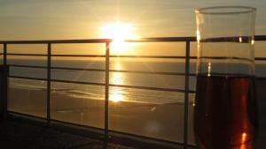 a glass of beer on a cruise ship with the sunset at Penthouse SEAFLOWER in Blankenberge