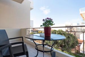 un balcone con tavolo e una pianta in vaso. di D. Apartments a Kalamáta