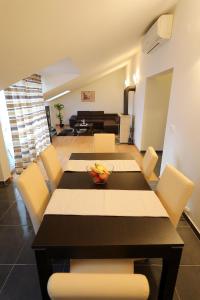a dining room with a table and chairs and a couch at Luxury Villa Nada with Pool in Petrcane