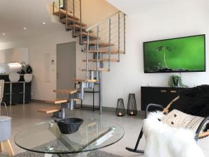 a living room with a glass table and a staircase at Appart T4 Christina contemporain, Vue Lac, climatisé avec parking in Aix-les-Bains