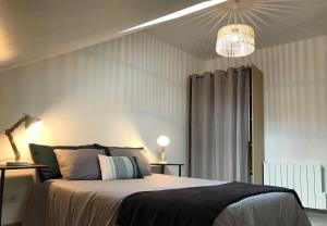 a bedroom with a large bed with a light fixture at Appart T4 Christina contemporain, Vue Lac, climatisé avec parking in Aix-les-Bains