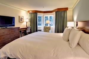 a bedroom with a large white bed and a desk at Kingsmill Resort in Williamsburg
