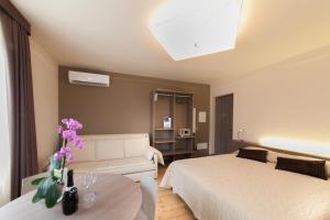 1 dormitorio con cama, sofá y mesa en International Rooms & Apartments en Sirmione