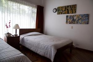 1 dormitorio con 2 camas individuales y ventana en Hostal Bogotá Real, en Bogotá