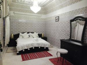 馬拉喀什的住宿－Riad Oum Ellkhir，一间卧室配有床、镜子和梳妆台
