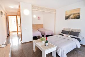 una habitación con una cama y un sofá y una mesa en Anne, en Salou