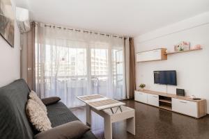 Una sala de estar con un sofá y un televisor. en Anne, en Salou
