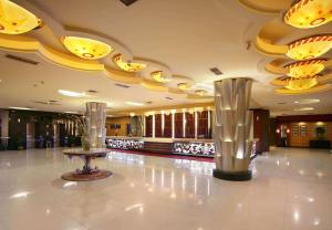un vestíbulo con dos jarrones de plata en el suelo en ASTON Pontianak Hotel and Convention Center en Pontianak