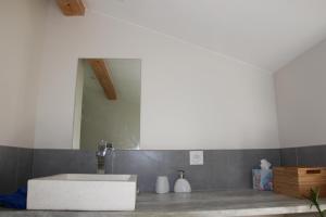 La salle de bains est pourvue d'un lavabo blanc et d'un miroir. dans l'établissement Grand duplex au calme en centre-ville, à Villefranche-sur-Saône