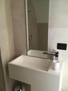 a white sink in a bathroom with a mirror at Appartamenti Ora del Garda in Nago-Torbole +33 photos