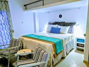 ein Schlafzimmer mit einem Bett und zwei Stühlen in der Unterkunft Zamboli in Chania