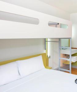 a bedroom with a bunk bed with a white bedsheet at ibis Budget - Fawkner in Melbourne