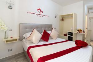 a bedroom with a large bed with red and white pillows at Ripetta Luxury Del Corso in Rome