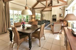a living room with a wooden table and chairs at Le Prieuré L´Atelier in Lanzac