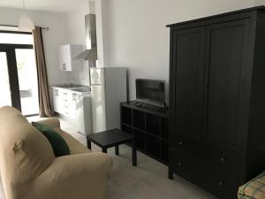 - un salon avec un canapé blanc et une armoire noire dans l'établissement Apartamento/Loft en Zona Céntrica I WIFI, à Jerez de la Frontera