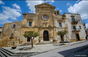 an old stone building with a clock on it at AL-ZABUT in Sambuca di Sicilia