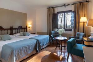 A bed or beds in a room at Parador de Jarandilla de la Vera