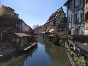 een rivier in het midden van een stad met gebouwen bij AU brochet in Colmar