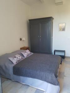 a bedroom with a bed and a black cabinet at Bastide Saint Jean Baptiste in Baudinard
