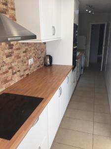 a kitchen with white cabinets and a wooden counter top at Campoamor Villa & Private Pool, Garden & Roof Terraces Distant Sea Views in Playas de Orihuela