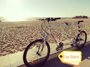 a bike parked on the beach with a sign for rent at Mar Beach Apartment in Póvoa de Varzim