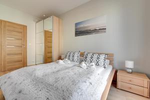 1 dormitorio con 1 cama grande y armario de madera en Wave Apartments Nowa Grobla Old Town, en Gdansk