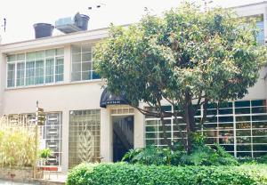 un edificio con un árbol delante de él en Casa Lelyte, en Bogotá