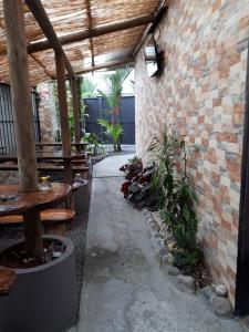 a patio with benches and a brick wall at Hotel y Cabinas del Trópico in Guápiles