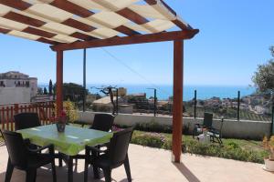 un patio con mesa, sillas y el océano en Casa con vista panoramica, en Sciacca